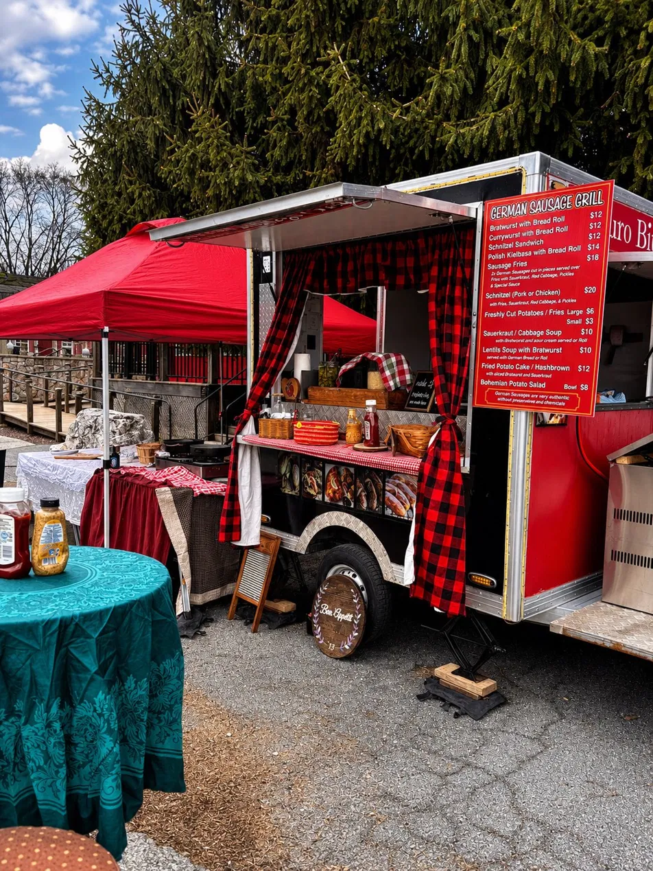 The Euro Bites trailer with red canopy and German Sausage Grill menu board